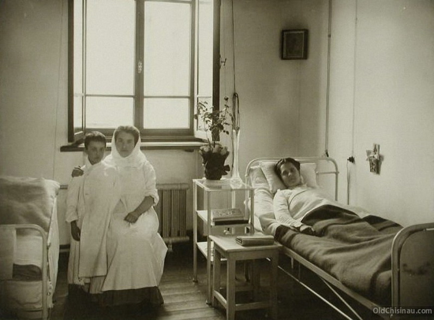 Больная и сестра милосердия с мальчиком в одноместной палате больницы.