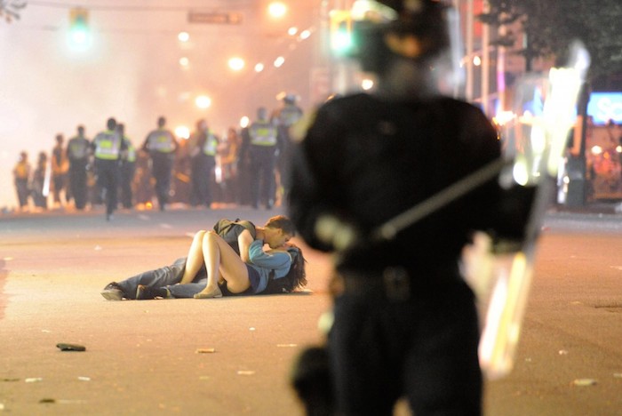 The greatest photo from the Vancouver riots of 2011 — and maybe ever- a couple kissing (really more than that) in front of riot police