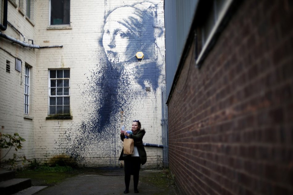 banksys-most-recent-work-a-homage-to-vermeers-girl-with-a-pearl-earring-trades-the-famous-earring-for-a-yellow-alarm-box