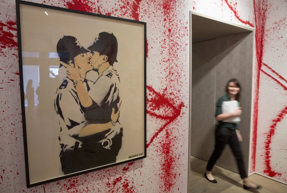 even-some-of-his-most-iconic-street-art-pieces-have-made-it-into-galleries-like-this-famous-stencil-of-two-english-police-officers-in-a-loving-embrace