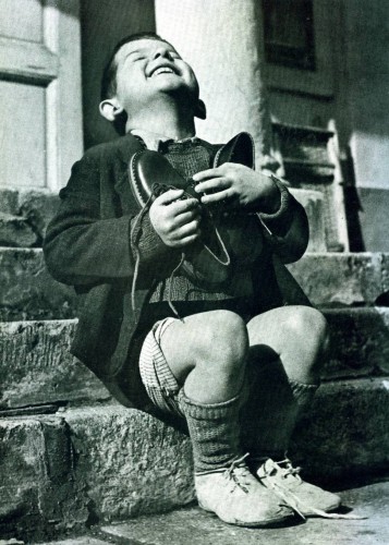 Австрийский сирота Верфел держит в руках новую пару обуви, подаренную американским Красным Крестом, 1946 г.